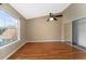 Well-lit bedroom boasts hardwood floors, a ceiling fan, and a spacious mirrored closet at 437 Fountainhead Cir # 283, Kissimmee, FL 34741