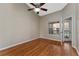 Bedroom with wood floors, fan, and window with community view, next to a doorway to the screened lanai at 437 Fountainhead Cir # 283, Kissimmee, FL 34741