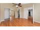 Open bedroom with wood floors, closet with mirrored doors, and doorways to the bathroom and kitchen at 437 Fountainhead Cir # 283, Kissimmee, FL 34741