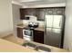 Galley kitchen with stainless steel refrigerator, dark cabinets, and laminate countertops at 4728 Walden Cir # 32, Orlando, FL 32811