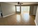 Living room featuring tile flooring, ceiling fan, and sliding glass doors to a screened lanai at 4728 Walden Cir # 32, Orlando, FL 32811