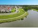 Aerial view of the neighborhood showcasing the pond, walking path, and surrounding community at 4800 Riverwalk Dr, St Cloud, FL 34771