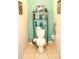 Bathroom featuring tile flooring, toilet, glass shelves, and aqua wall at 4800 Riverwalk Dr, St Cloud, FL 34771