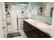 Bright bathroom showcasing double sinks, walk-in shower, and tile flooring at 4800 Riverwalk Dr, St Cloud, FL 34771