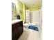 Bathroom featuring shower over tub with curtain, accessible stool, and dark vanity at 4800 Riverwalk Dr, St Cloud, FL 34771