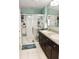 Bright bathroom showcasing double sinks, walk-in shower, and tile flooring at 4800 Riverwalk Dr, St Cloud, FL 34771