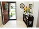 Welcoming entryway with an open door, decorative table, mirror, and tiled flooring at 4800 Riverwalk Dr, St Cloud, FL 34771