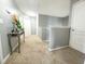 Bright upstairs hallway with carpet flooring, neutral walls, and decorative table at 4800 Riverwalk Dr, St Cloud, FL 34771
