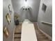 Carpeted staircase with neutral walls, decorative artwork, and modern lighting fixtures at 4800 Riverwalk Dr, St Cloud, FL 34771