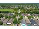 A high aerial view shows a beautiful blue house with a lovely backyard, manicured lawn and tall mature trees at 4903 Santa Clara Dr, Orlando, FL 32837
