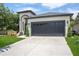 Front exterior of house with a two-car garage, an inviting walkway, and a gray roof at 4903 Santa Clara Dr, Orlando, FL 32837