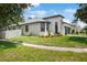 View of the landscaped front yard and charming single-Gathering home with a gray roof and a two-car garage at 4903 Santa Clara Dr, Orlando, FL 32837