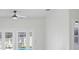 An all-white living room with a ceiling fan and French doors leading to a pool at 4903 Santa Clara Dr, Orlando, FL 32837