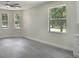 Open living room showcasing gray floors and three windows allowing natural sunlight at 4903 Santa Clara Dr, Orlando, FL 32837