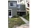 Two-story townhouse with a walkway, patio, and lush landscaping surrounding the front entrance at 5826 Peregrine Ave # F01, Orlando, FL 32819
