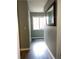 A hallway view showcasing the flooring, a mirror, and a window at the end of the hall at 5826 Peregrine Ave # F01, Orlando, FL 32819