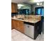 Kitchen area with stainless steel dishwasher and gold granite countertops, providing an elegant cooking space at 5826 Peregrine Ave # F01, Orlando, FL 32819