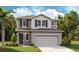 Two-story home with gray stucco and siding, complemented by blue shutters and a two-car garage at 746 Lake Dell Ave, Dundee, FL 33838