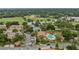 Aerial shot of homes, tennis court, and pool area with lush greenery, surrounded by a green athletic field at 7667 Sugar Bend Dr # 7667, Orlando, FL 32819