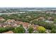 A high-angle aerial view shows townhomes surrounded by green trees and common areas at 7667 Sugar Bend Dr # 7667, Orlando, FL 32819