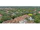 A high-angle aerial view shows townhomes surrounded by green trees and common areas at 7667 Sugar Bend Dr # 7667, Orlando, FL 32819