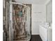 Bathroom featuring tiled shower with glass door, sink with faucet, and tiled wall at 7667 Sugar Bend Dr # 7667, Orlando, FL 32819