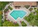Overhead shot of a geometrically-shaped community pool showcasing tiled deck, lounge chairs, and green landscaping at 7667 Sugar Bend Dr # 7667, Orlando, FL 32819