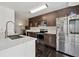 Modern kitchen featuring stainless steel appliances, white countertops, and dark wood cabinets at 7667 Sugar Bend Dr # 7667, Orlando, FL 32819
