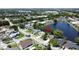Scenic aerial view of a residential area with a tranquil lake, mature trees, and well-maintained homes at 86 Blackberry Creek Dr, St Cloud, FL 34769