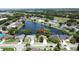 Scenic aerial view of a residential area featuring a tranquil lake, lush greenery, and well-maintained homes at 86 Blackberry Creek Dr, St Cloud, FL 34769