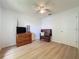 Bright bedroom featuring wood-look floors, a ceiling fan, and a wood dresser at 86 Blackberry Creek Dr, St Cloud, FL 34769