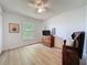 Bright bedroom featuring wood-look floors, a window, ceiling fan, and a wood dresser at 86 Blackberry Creek Dr, St Cloud, FL 34769