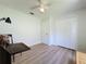 Bright bedroom featuring wood-look floors, ceiling fan, closet, and a personal desk at 86 Blackberry Creek Dr, St Cloud, FL 34769