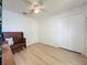 Bright bedroom featuring wood-look floors, ceiling fan, closet, and a bench at 86 Blackberry Creek Dr, St Cloud, FL 34769