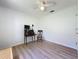 Bright bedroom featuring wood-look floors, ceiling fan, closet, and a personal desk at 86 Blackberry Creek Dr, St Cloud, FL 34769