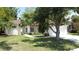 Charming home with a well-manicured lawn, mature tree, and a welcoming pathway to the front entrance at 86 Blackberry Creek Dr, St Cloud, FL 34769
