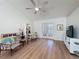 Bright living room features wood floors, double doors, and a ceiling fan at 86 Blackberry Creek Dr, St Cloud, FL 34769