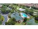 Aerial view of a community pool and clubhouse surrounded by lush landscaping and parking lots at 9055 Treasure Trove Ln # 207, Kissimmee, FL 34747
