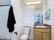 This bathroom features a toilet, sink with wooden cabinets, and mirror at 9055 Treasure Trove Ln # 207, Kissimmee, FL 34747