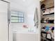 Bathroom featuring a jacuzzi tub, white tile and linen closet with shelving at 9055 Treasure Trove Ln # 207, Kissimmee, FL 34747