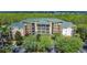 Aerial view of a multi-story building with balconies and surrounding green trees at 9055 Treasure Trove Ln # 207, Kissimmee, FL 34747