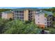 Three-story condo building with green roof surrounded by lush trees and landscaping at 9055 Treasure Trove Ln # 207, Kissimmee, FL 34747