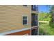 This is a view of the exterior of the condo with a screened patio overlooking the landscape at 9055 Treasure Trove Ln # 207, Kissimmee, FL 34747