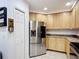 Modern kitchen features stainless steel appliances, wood cabinets, and tile flooring at 9055 Treasure Trove Ln # 207, Kissimmee, FL 34747