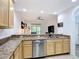 Kitchen with stainless steel dishwasher, tile floors and eat-in bar looking towards the living area at 9055 Treasure Trove Ln # 207, Kissimmee, FL 34747