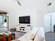 Inviting living room with white sofa, modern decor, and view to dining and patio at 9055 Treasure Trove Ln # 207, Kissimmee, FL 34747