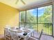 Enjoy outdoor dining on this screened patio with a table, chairs and a view of nature at 9055 Treasure Trove Ln # 207, Kissimmee, FL 34747