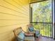 Relax on this screened patio with wicker seating, pillows, and a lush view of nature at 9055 Treasure Trove Ln # 207, Kissimmee, FL 34747