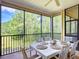 Relaxing screened patio featuring a dining table with comfortable seating and beautiful wooded views at 9055 Treasure Trove Ln # 207, Kissimmee, FL 34747