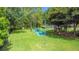 Outdoor picnic area featuring barbecue grill and picnic tables surrounded by lush greenery and ample parking at 9055 Treasure Trove Ln # 207, Kissimmee, FL 34747